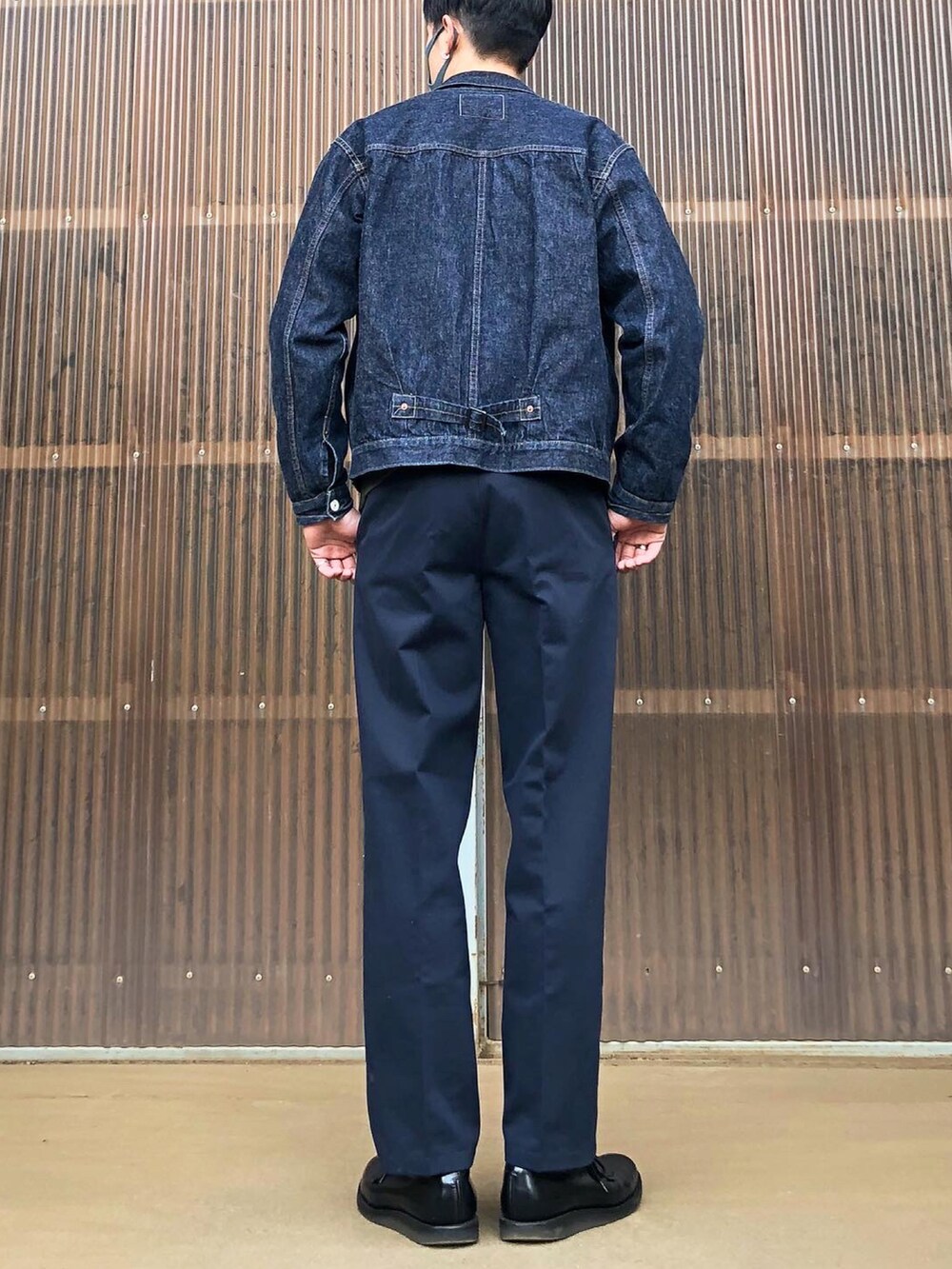 グリーン系のスウェット、ブルー系のデニムジャケット、ブルー系のスラックスを着用したメンズの秋コーディネートの2枚目の写真