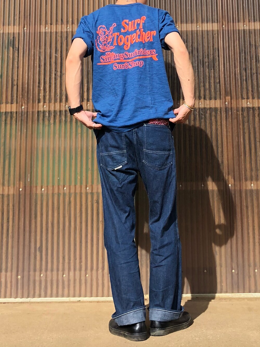 ブルー系のTシャツ/カットソー、ブルー系のデニムパンツ、ブラック系のシューズを着用したメンズの秋コーディネートの2枚目の写真
