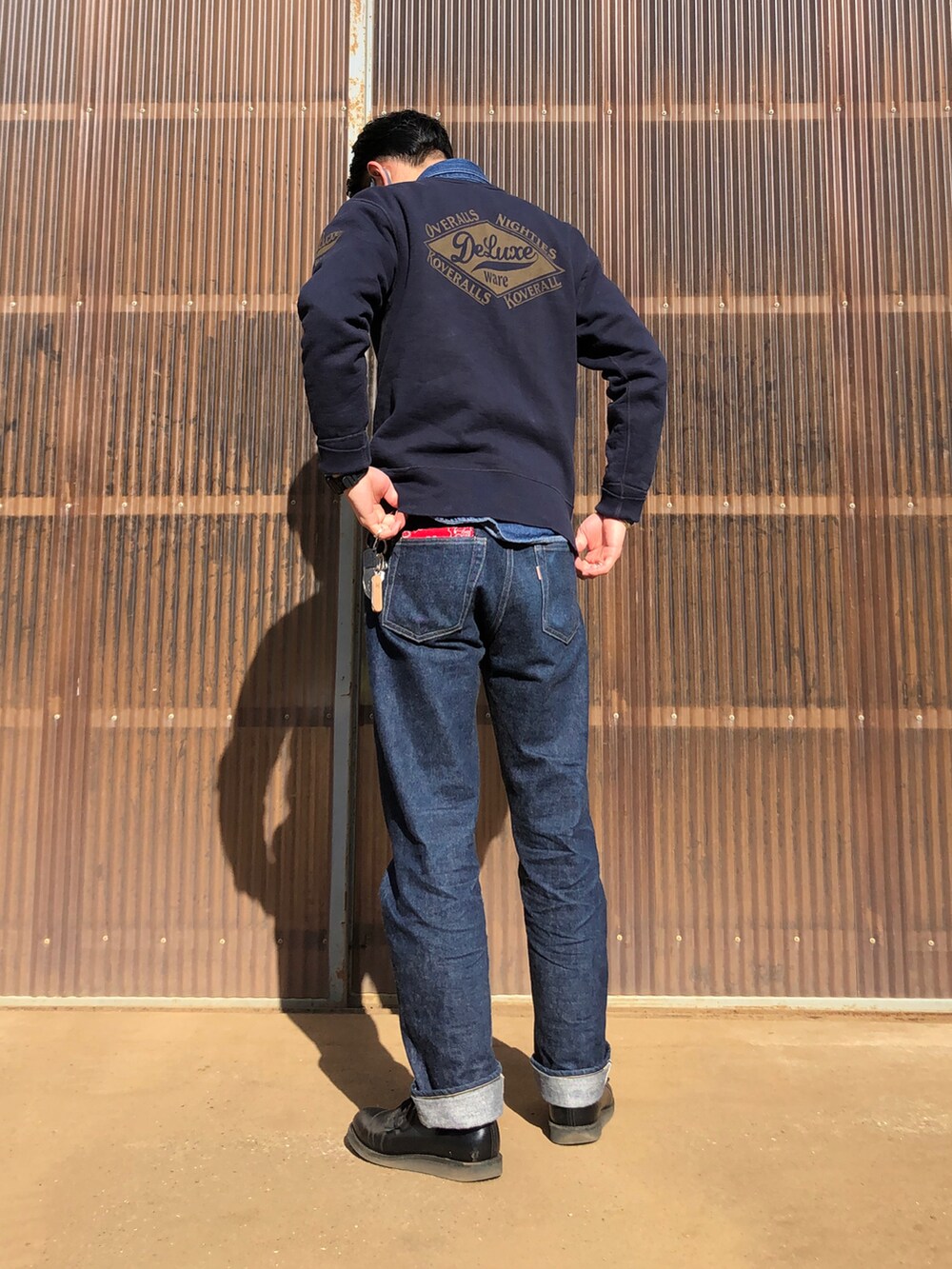 ブルー系のデニムパンツ、ブラック系のブーツ、グリーン系のミリタリージャケットを着用したメンズの冬コーディネートの2枚目の写真