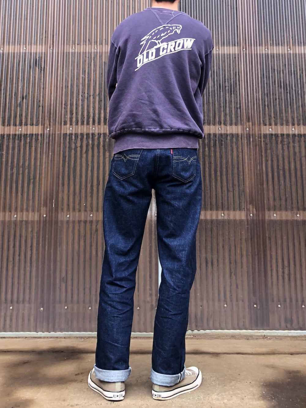 ベージュ系のスニーカー、ブルー系のデニムパンツ、パープル系のスウェットを着用したメンズの秋コーディネートの2枚目の写真