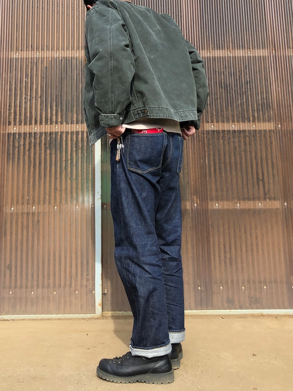 ブルー系のデニムパンツ、ブラック系のブーツ、ベージュ系のスウェットを着用したメンズの春コーディネートの2枚目の写真