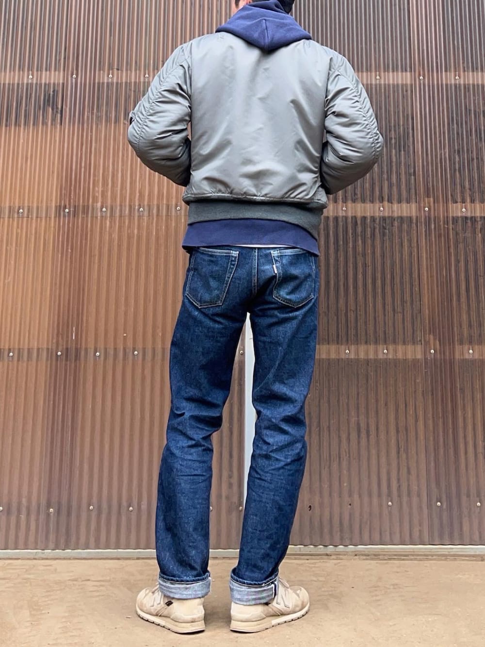 ブルー系のデニムパンツ、ベージュ系のスニーカー、ブルー系のパーカーを着用したメンズの冬コーディネートの2枚目の写真