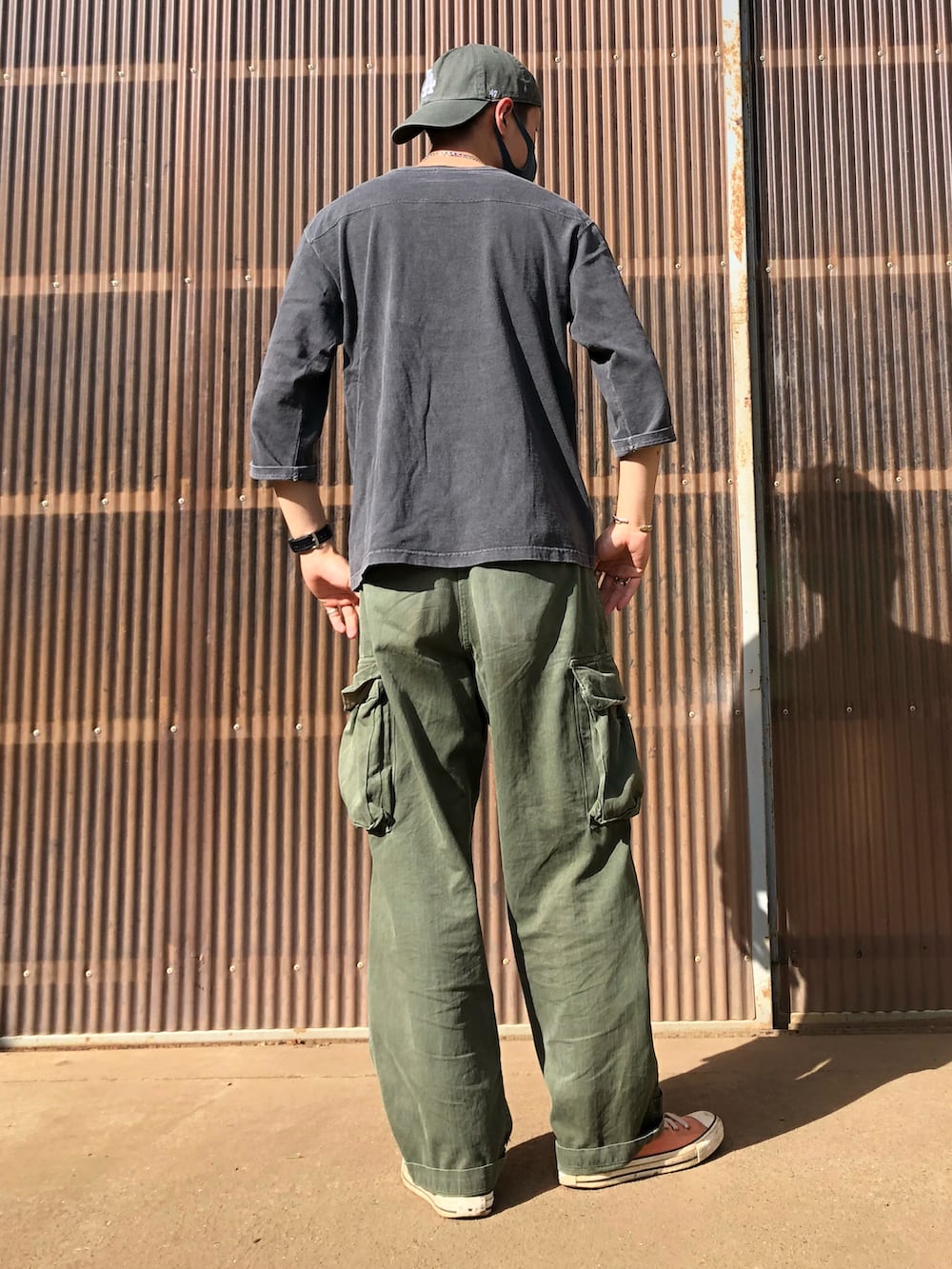 グリーン系のカーゴパンツ、ピンク系のスニーカー、ブラック系のTシャツ/カットソーを着用したメンズの夏コーディネートの2枚目の写真