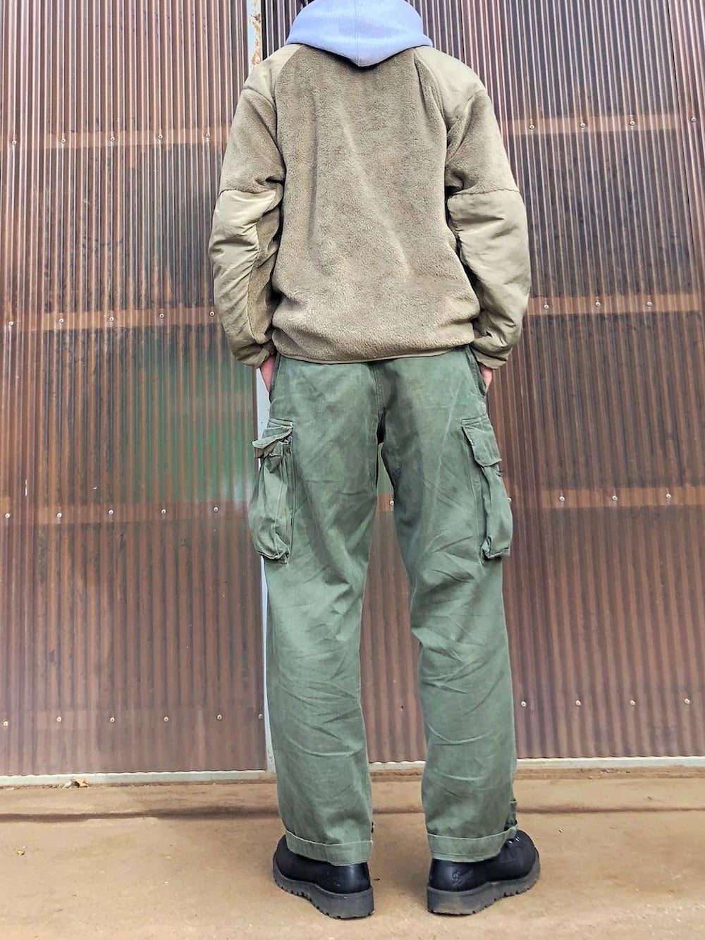 グレー系のパーカー、ベージュ系のミリタリージャケット、グリーン系のカーゴパンツを着用したメンズの秋コーディネートの2枚目の写真