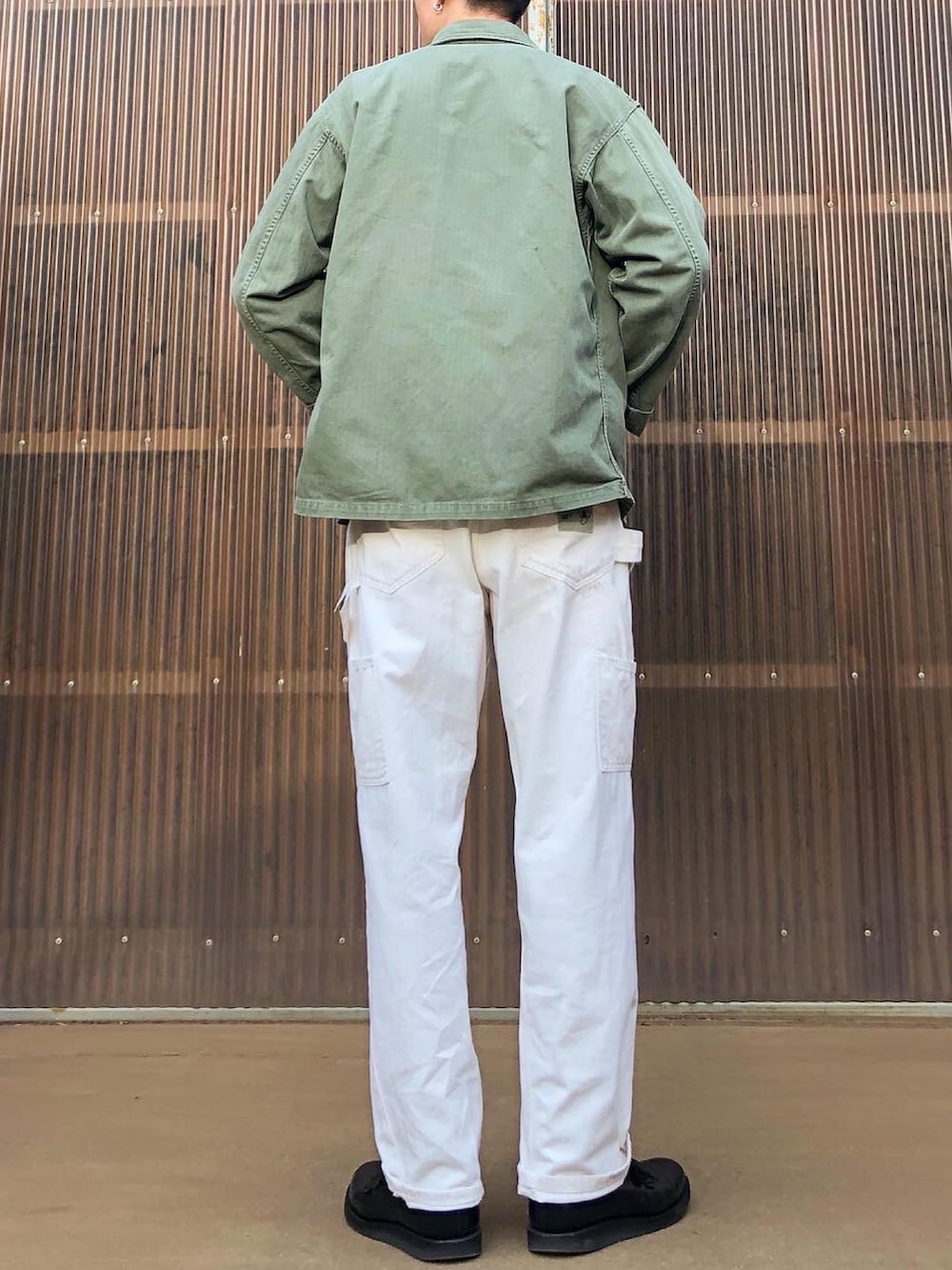 ブルー系のスウェット、グリーン系のミリタリージャケット、ベージュ系のその他パンツを着用したメンズの秋コーディネートの2枚目の写真