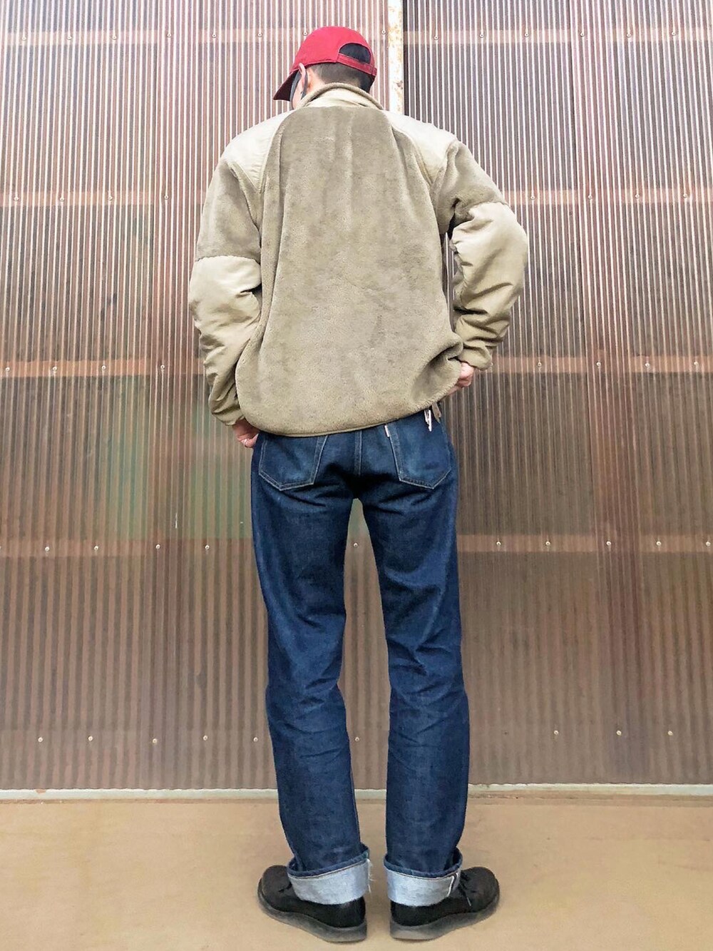 ベージュ系のミリタリージャケット、ベージュ系のスウェット、ブルー系のデニムパンツを着用したメンズの秋コーディネートの2枚目の写真
