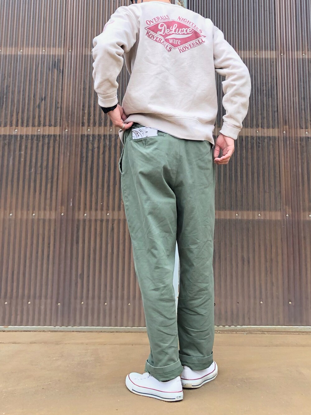 ホワイト系のスニーカー、グリーン系のチノパンツ、ベージュ系のスウェットを着用したメンズの春コーディネートの2枚目の写真