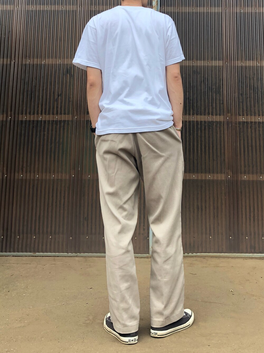 ベージュ系のチノパンツ、ブラック系のスニーカー、ホワイト系のTシャツ/カットソーを着用したメンズの夏コーディネートの2枚目の写真