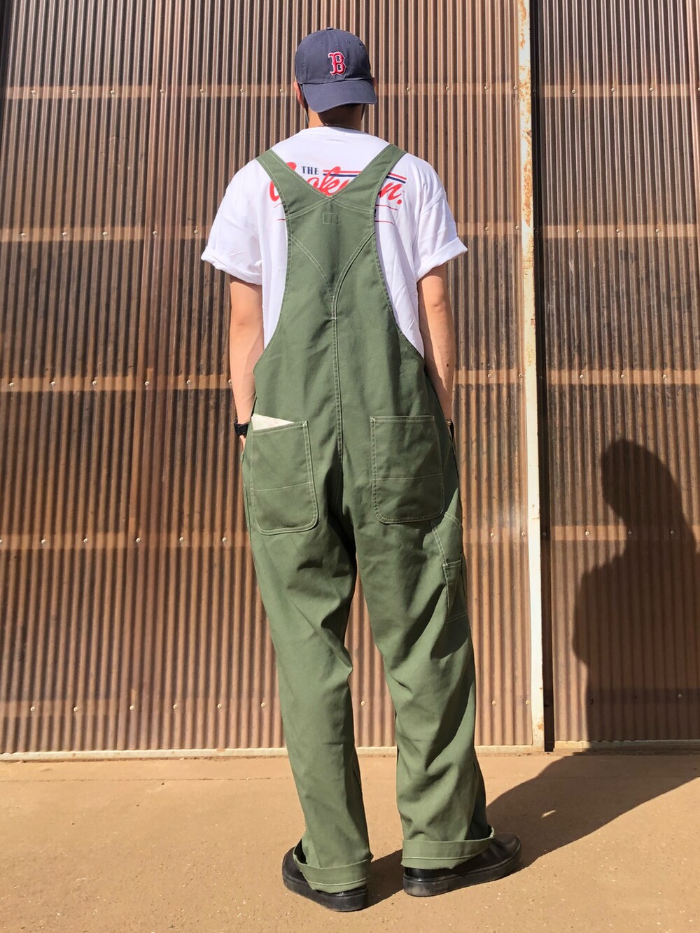 ホワイト系のTシャツ/カットソー、グリーン系のサロペット/オーバーオール、ブラック系のシューズを着用したメンズの夏コーディネートの2枚目の写真