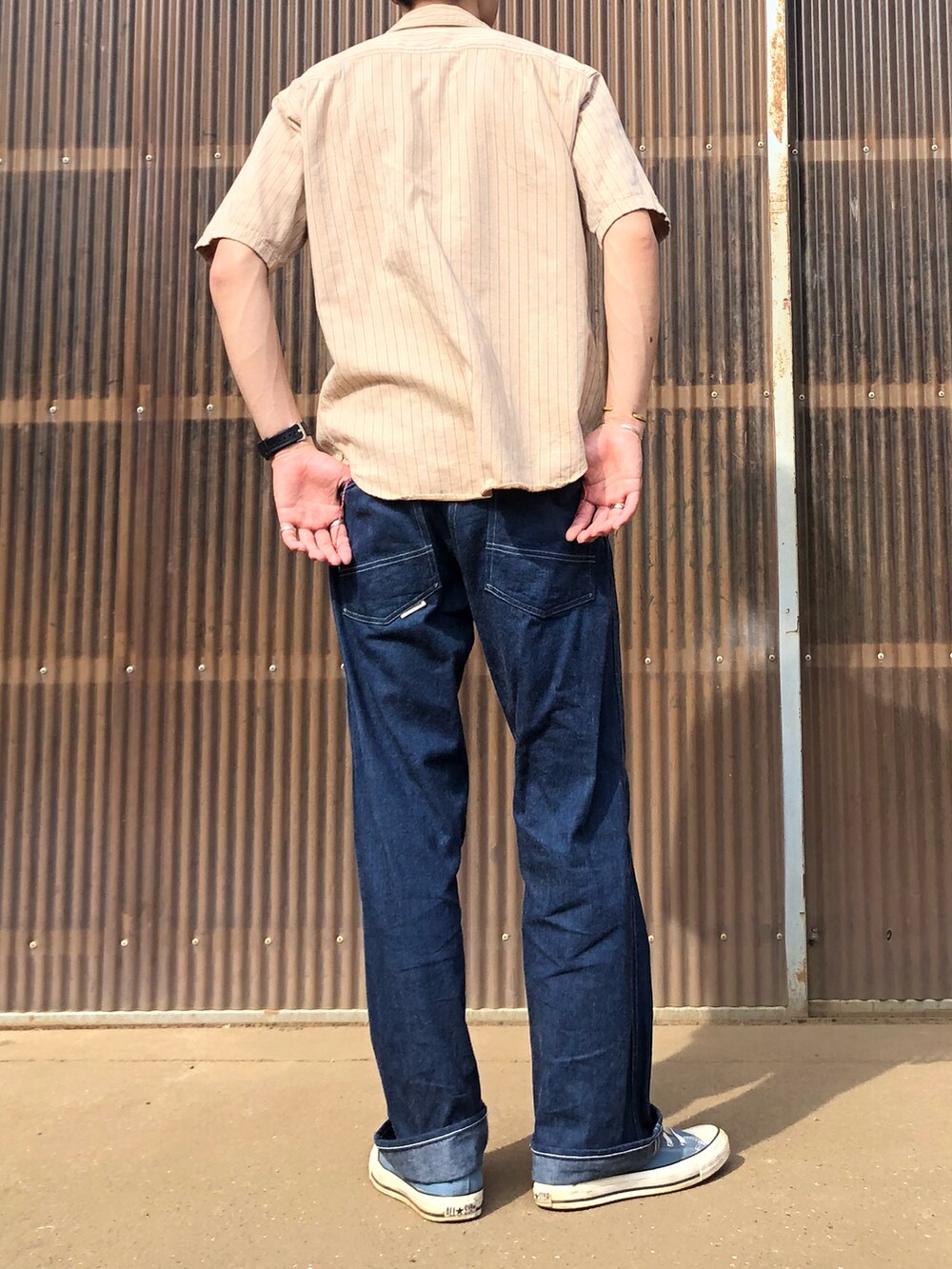 ブルー系のデニムパンツ、ブルー系のスニーカー、ベージュ系のシャツ/ブラウスを着用したメンズの夏コーディネートの2枚目の写真