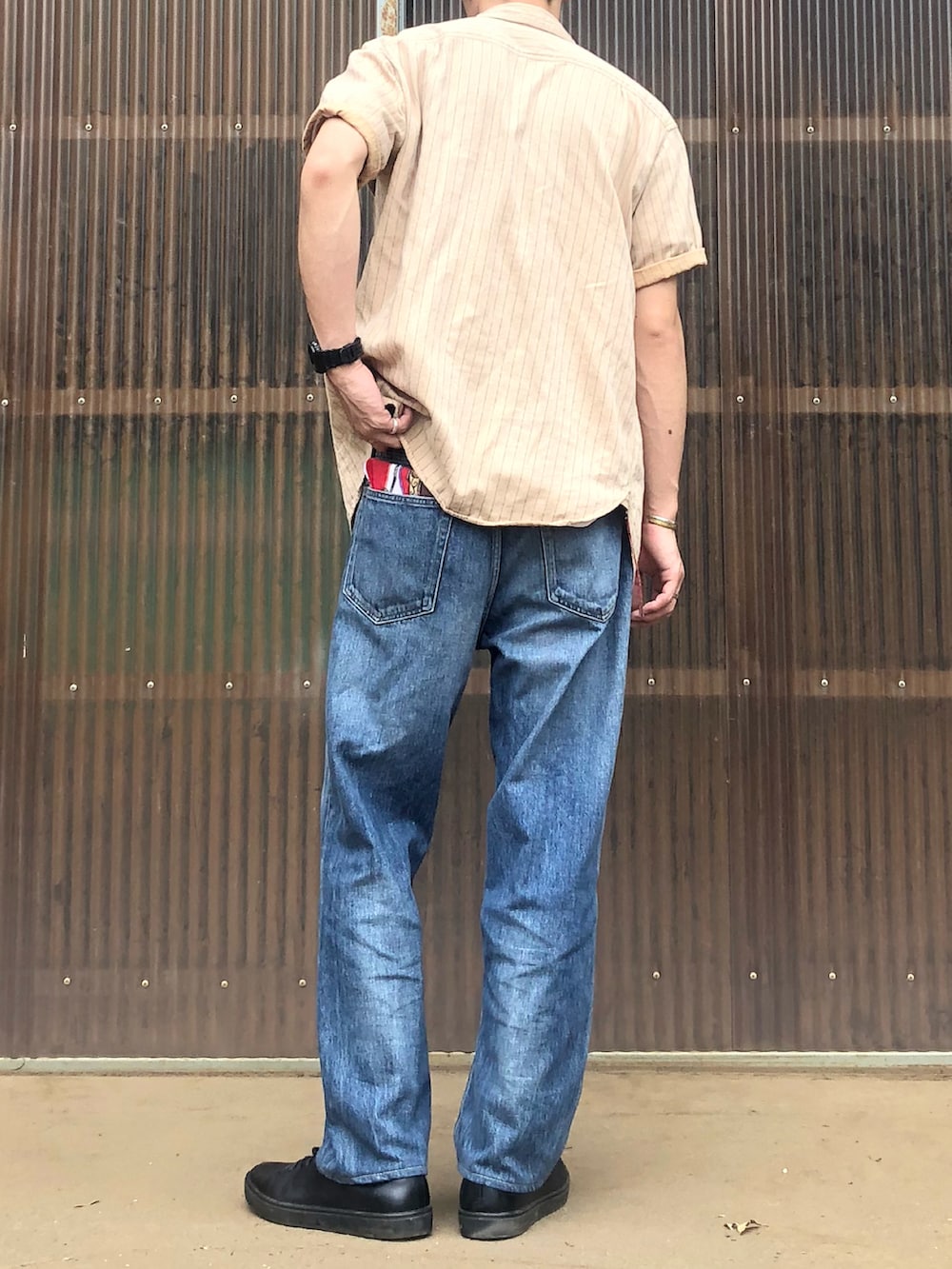 ブルー系のデニムパンツ、ブラック系のシューズ、ベージュ系のシャツ/ブラウスを着用したメンズの秋コーディネートの2枚目の写真