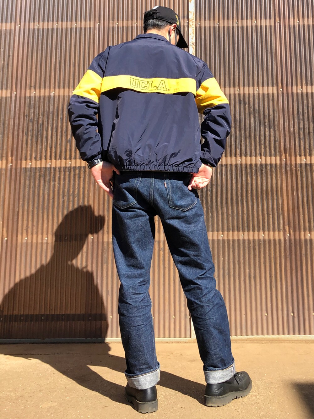 ブラック系のブーツ、ブルー系のデニムパンツ、グレー系のスウェットを着用したメンズの冬コーディネートの2枚目の写真