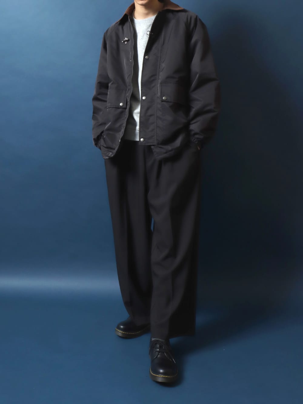 ブラック系のドレスシューズ、ブラック系のスラックス、ホワイト系のスウェットを着用したメンズの秋コーディネートの2枚目の写真