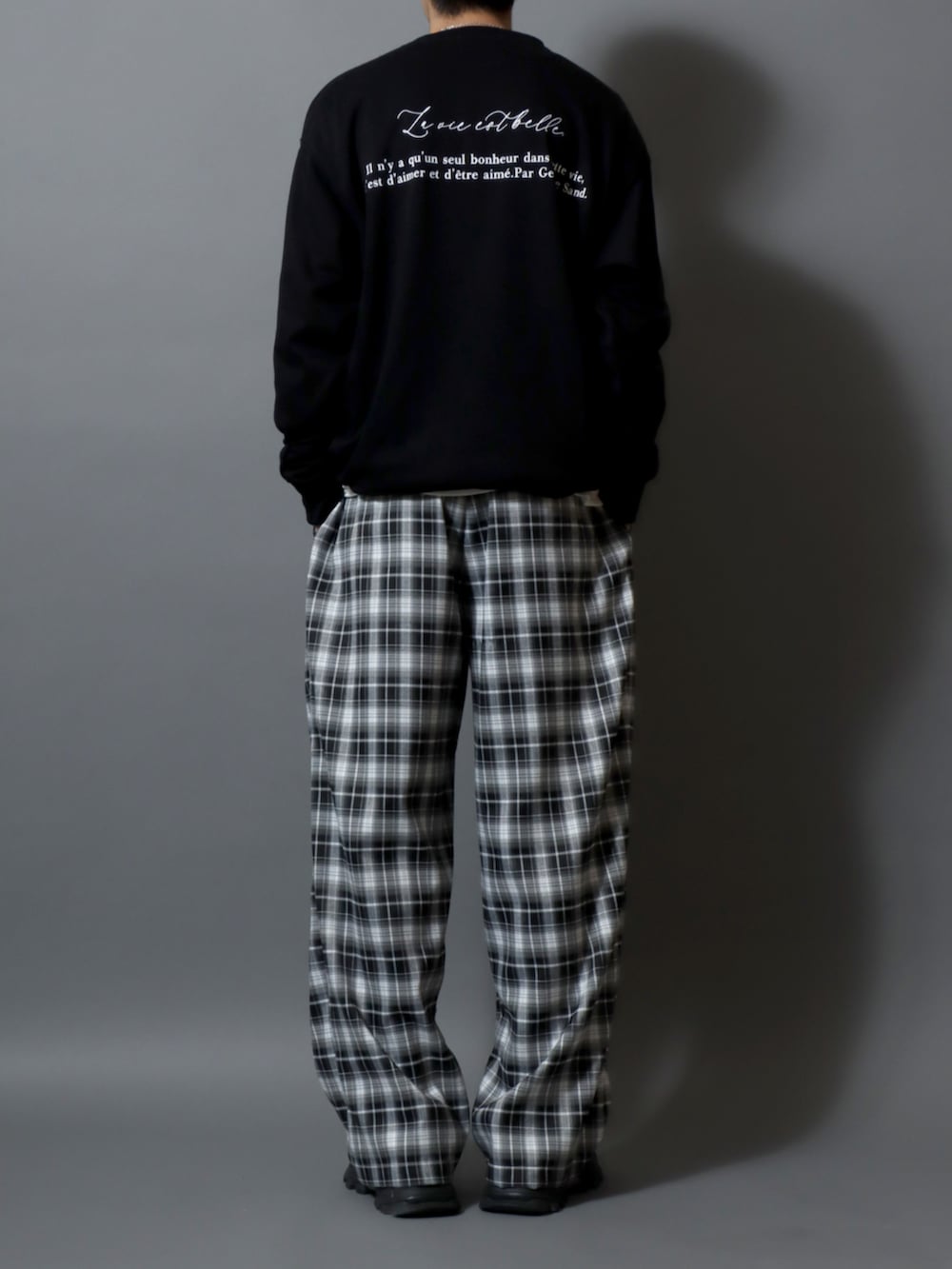 ブラック系のスウェット、その他のスラックスを着用したメンズの冬コーディネートの2枚目の写真