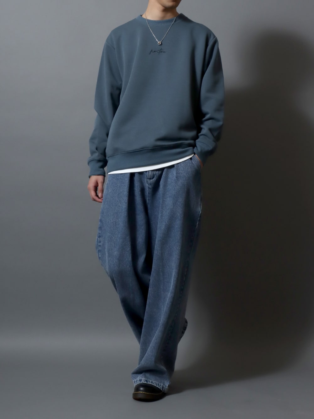 ブルー系のデニムパンツ、ブルー系のスウェット、ブラック系のベルトを着用したメンズの春コーディネートの2枚目の写真