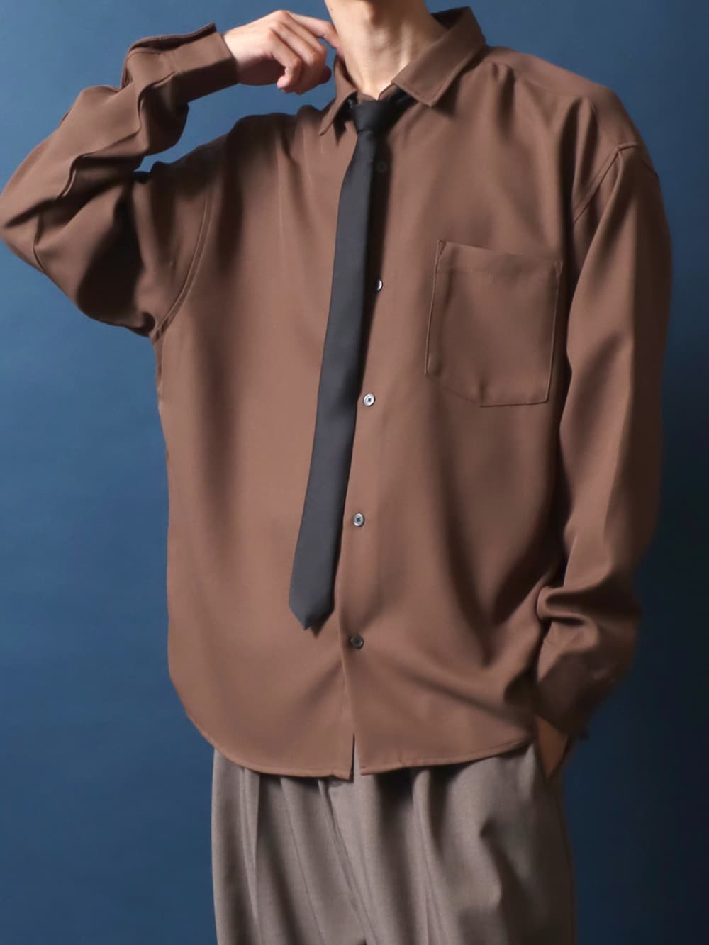 ブラック系のドレスシューズ、ブラウン系のスラックス、ブラウン系のシャツ/ブラウスを着用したメンズの秋コーディネートの3枚目の写真