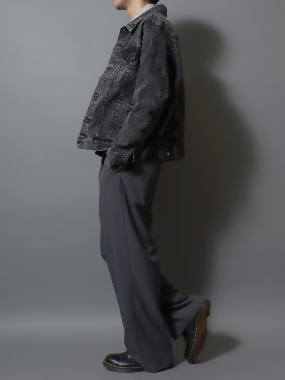 ブラック系のドレスシューズ、グレー系のスラックス、ブラック系のデニムジャケットを着用したメンズの冬コーディネートの3枚目の写真