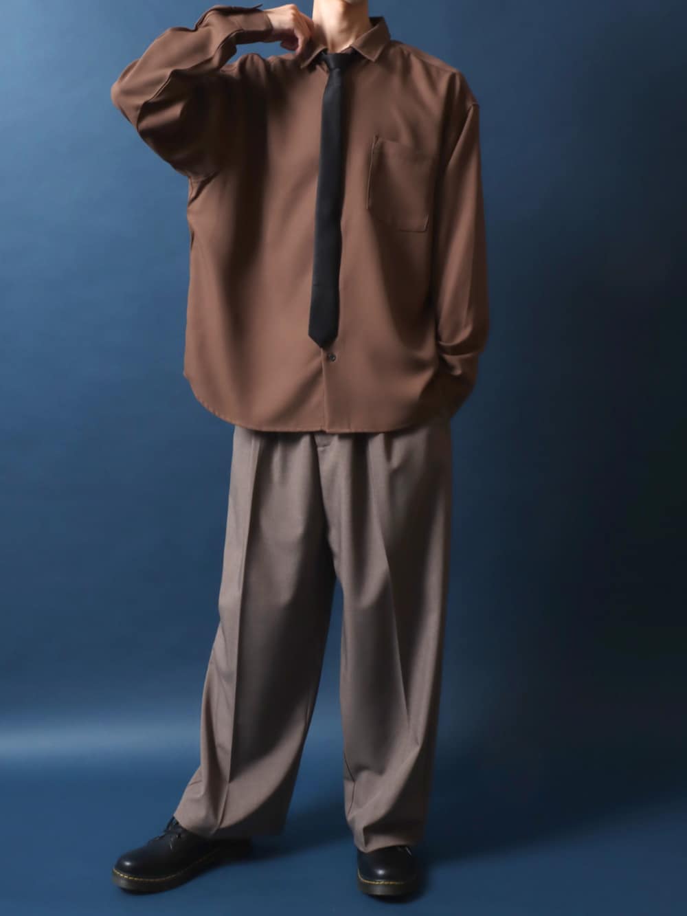 ブラック系のドレスシューズ、ブラウン系のスラックス、ブラウン系のシャツ/ブラウスを着用したメンズの秋コーディネートの2枚目の写真