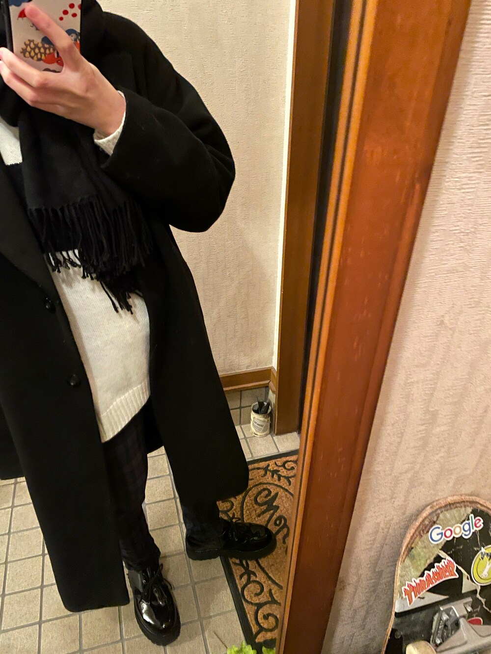 ブラック系のジャケット/アウター、ベージュ系のニット/セーター、ブラック系のシューズを着用したレディースの冬コーディネートの2枚目の写真