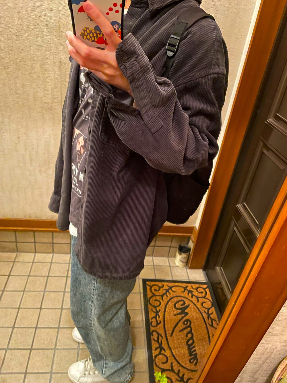 グレー系のTシャツ/カットソー、ブラック系のシャツ/ブラウス、ブルー系のパンツを着用したレディースの秋コーディネートの2枚目の写真