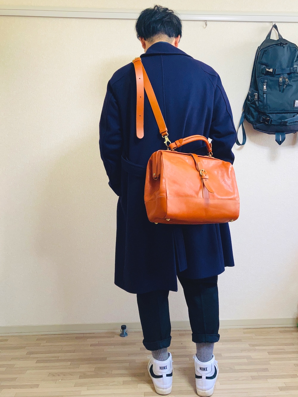 ブルー系のニット/セーター、ブルー系のチェスターコート、ブラック系のスラックスを着用したメンズの秋コーディネートの2枚目の写真