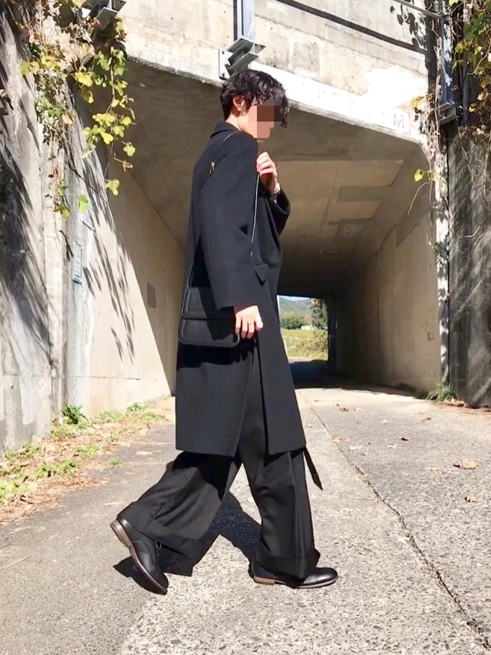 ブラック系のトップス、ブラック系のチェスターコート、ブラック系のその他パンツを着用したメンズの秋コーディネートの3枚目の写真