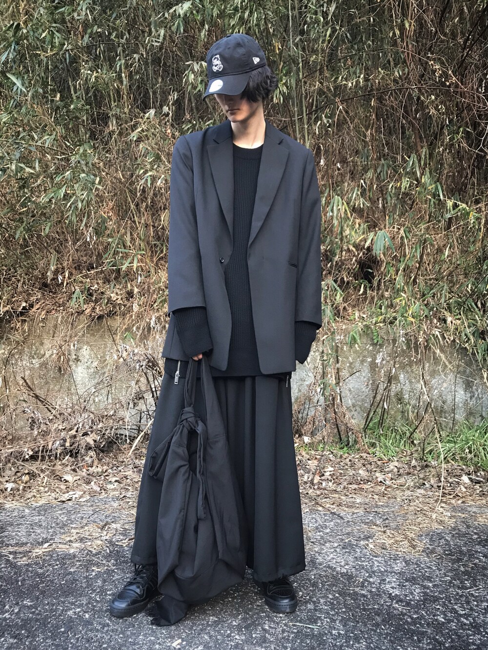 ブラック系のニット/セーター、ブラック系のテーラードジャケット、ブラック系のパンツを着用したメンズの冬コーディネートの2枚目の写真