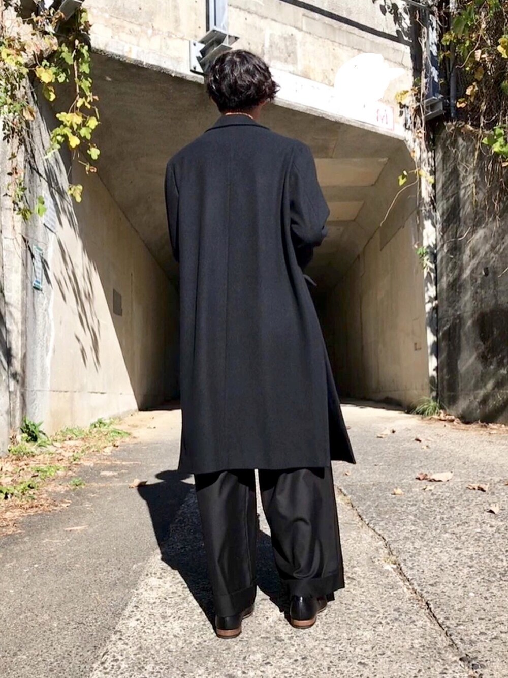 ブラック系のトップス、ブラック系のチェスターコート、ブラック系のその他パンツを着用したメンズの秋コーディネートの4枚目の写真