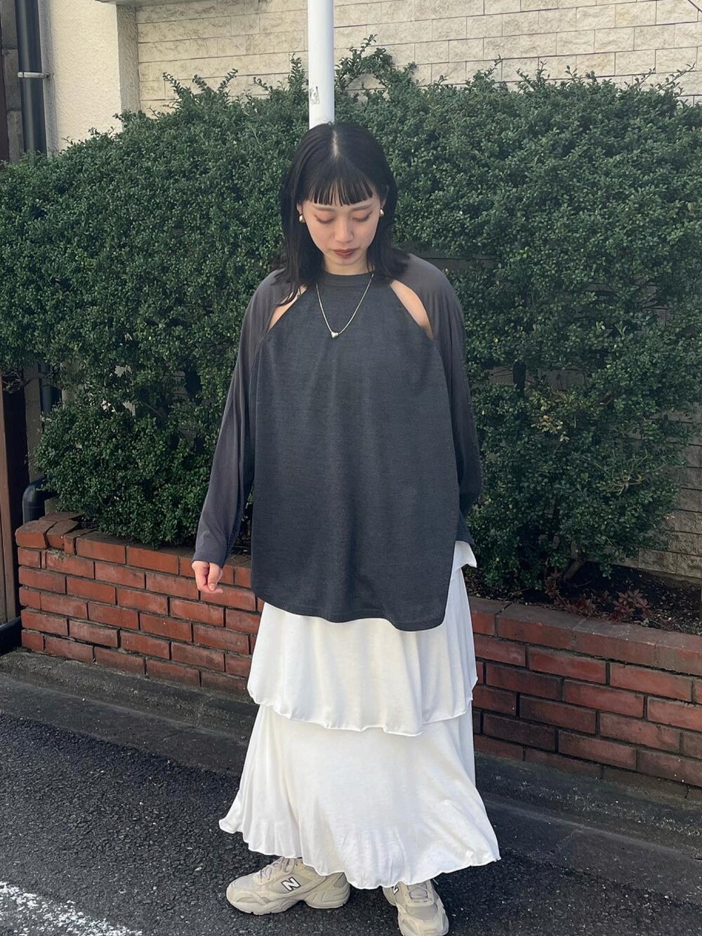 グレー系のTシャツ/カットソー、ホワイト系のスカートを着用したレディースの春コーディネートの2枚目の写真