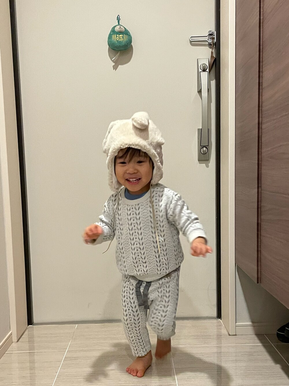 ホワイト系のパンツ、ベージュ系の帽子を着用したキッズの冬コーディネートの2枚目の写真