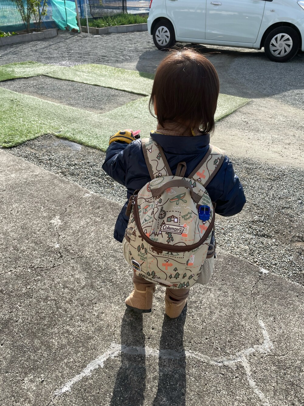 ブルー系のナイロンジャケット、ブラウン系のブーツ、ベージュ系のバックパック/リュックを着用したキッズの冬コーディネートの2枚目の写真