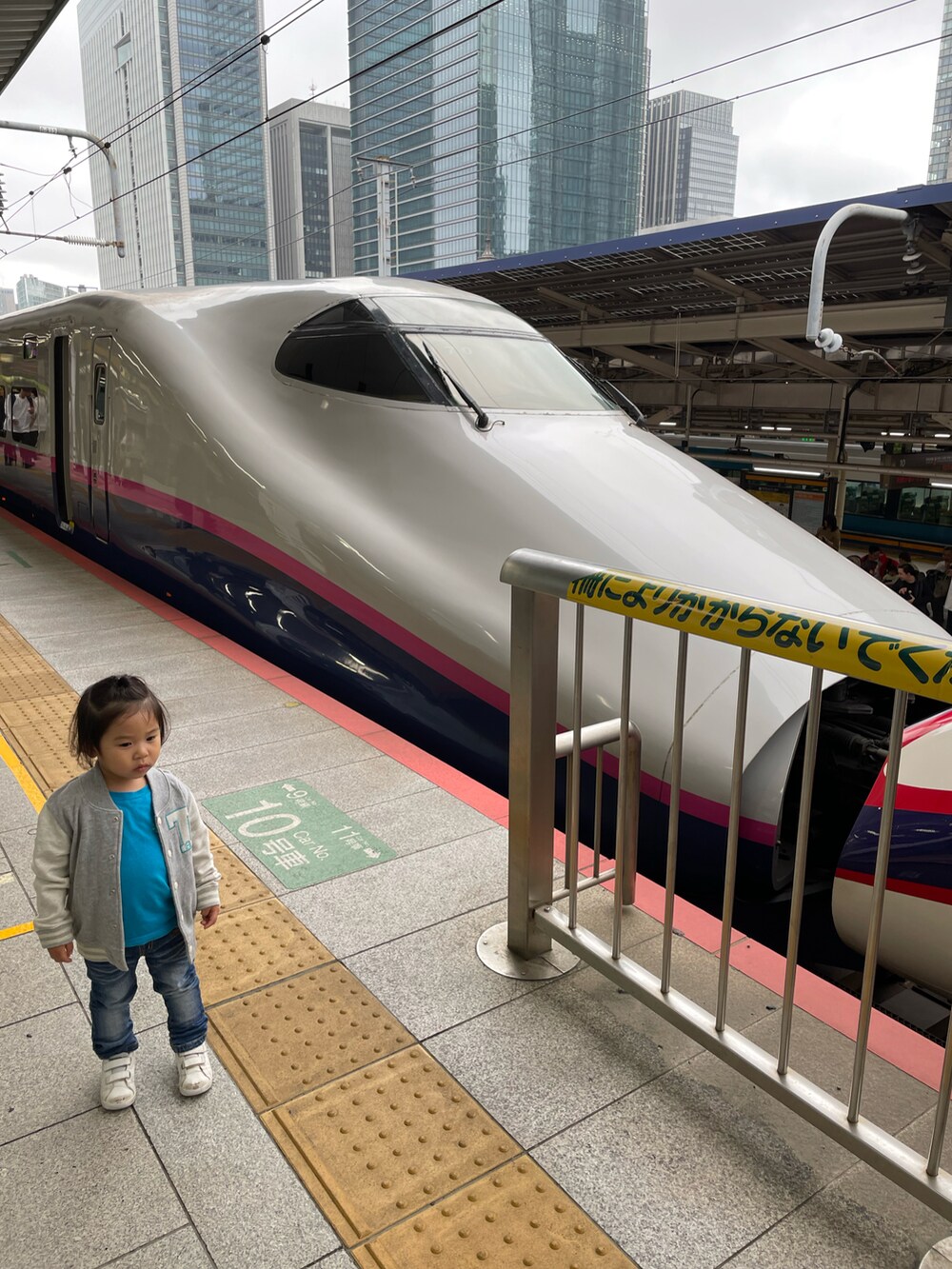 グレー系のスタジャン、ブルー系のデニムパンツ、ホワイト系のスニーカーを着用したキッズの夏コーディネートの4枚目の写真