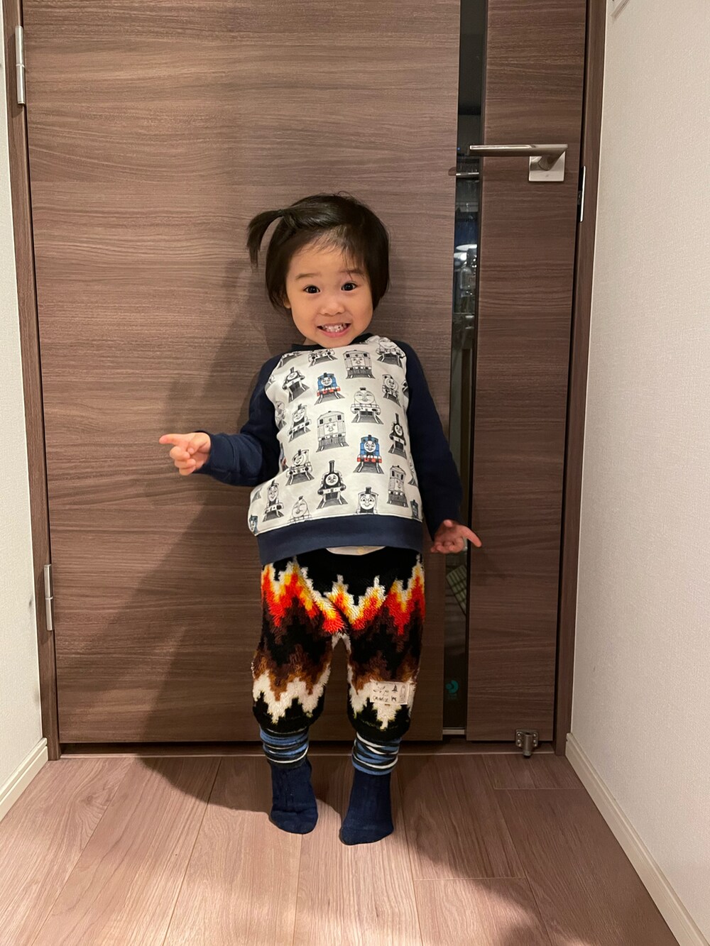 ホワイト系のスウェット、ブラック系のパンツ、ブルー系のレッグウォーマーを着用したキッズの冬コーディネートの3枚目の写真