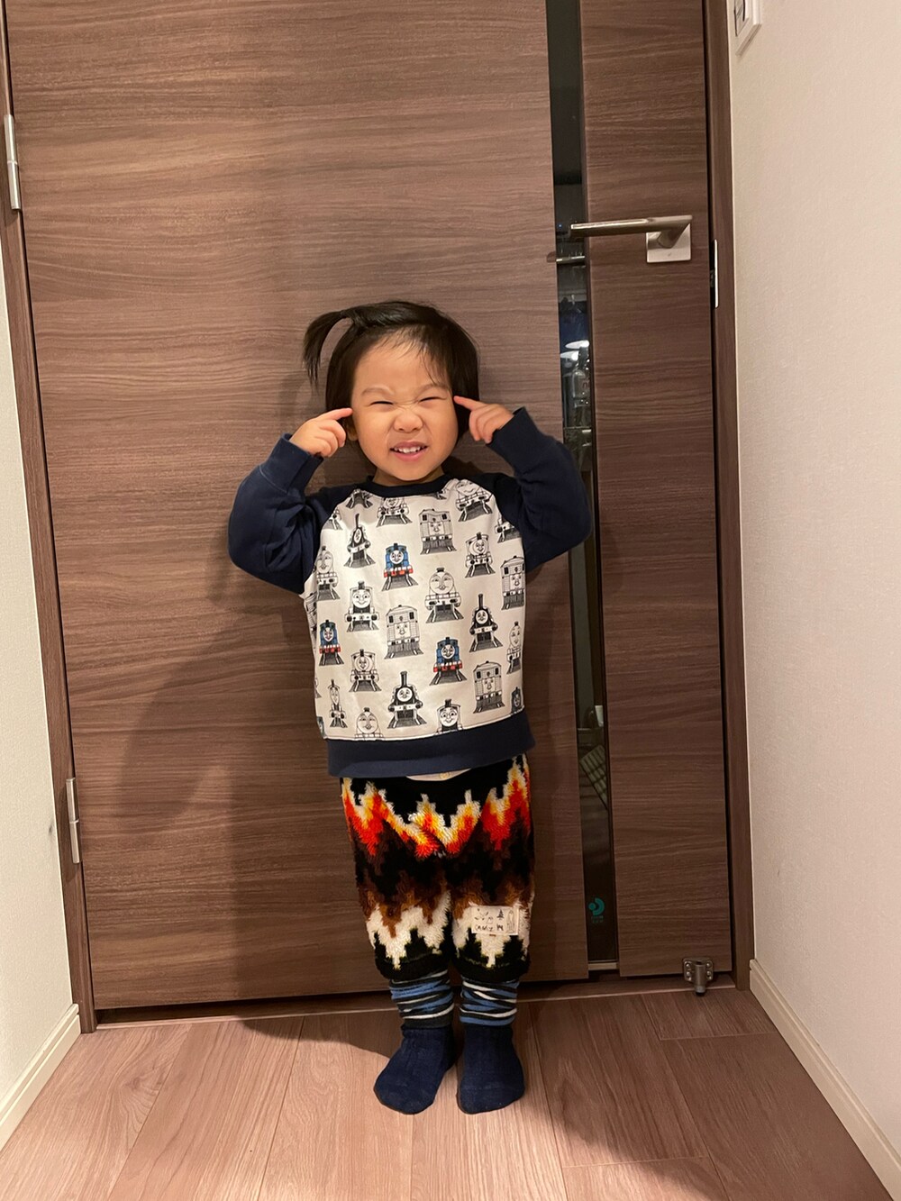 ホワイト系のスウェット、ブラック系のパンツ、ブルー系のレッグウォーマーを着用したキッズの冬コーディネートの2枚目の写真