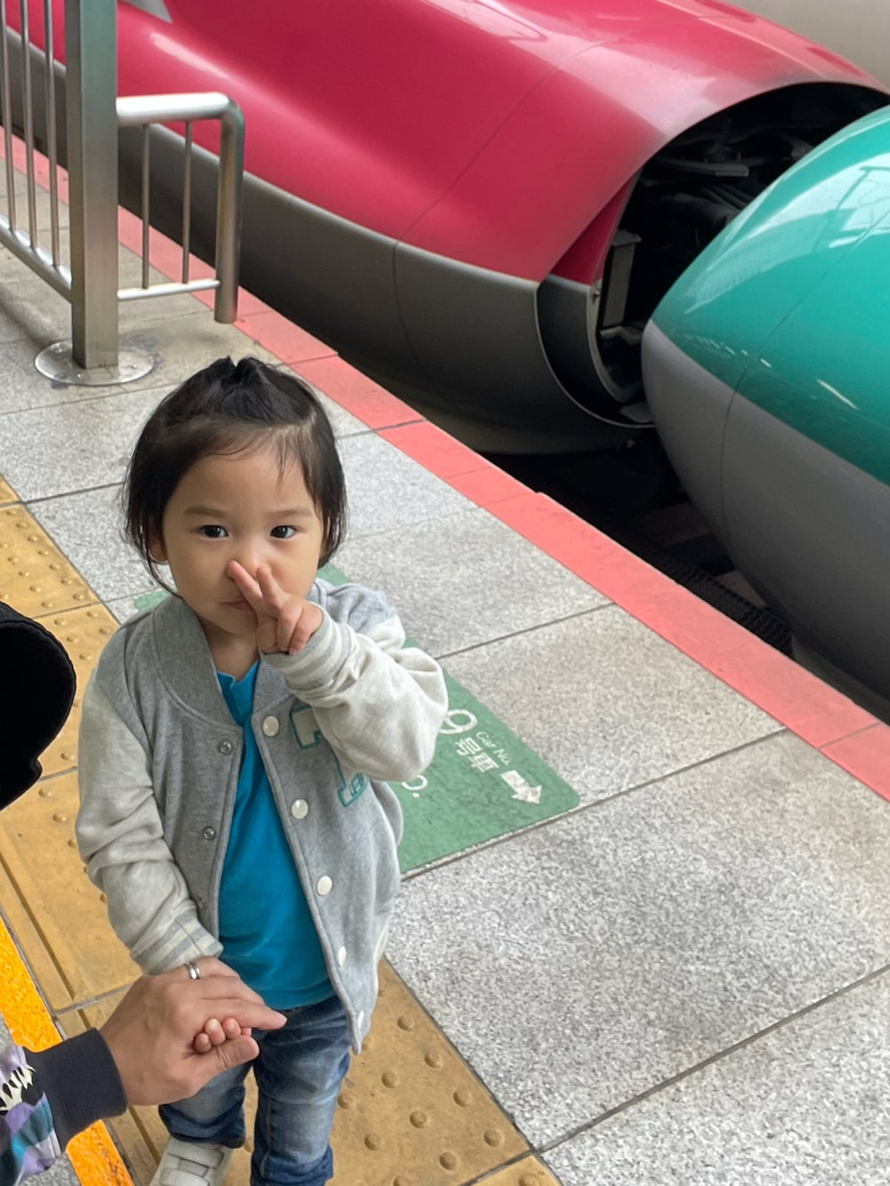 グレー系のスタジャン、ブルー系のデニムパンツ、ホワイト系のスニーカーを着用したキッズの夏コーディネートの5枚目の写真