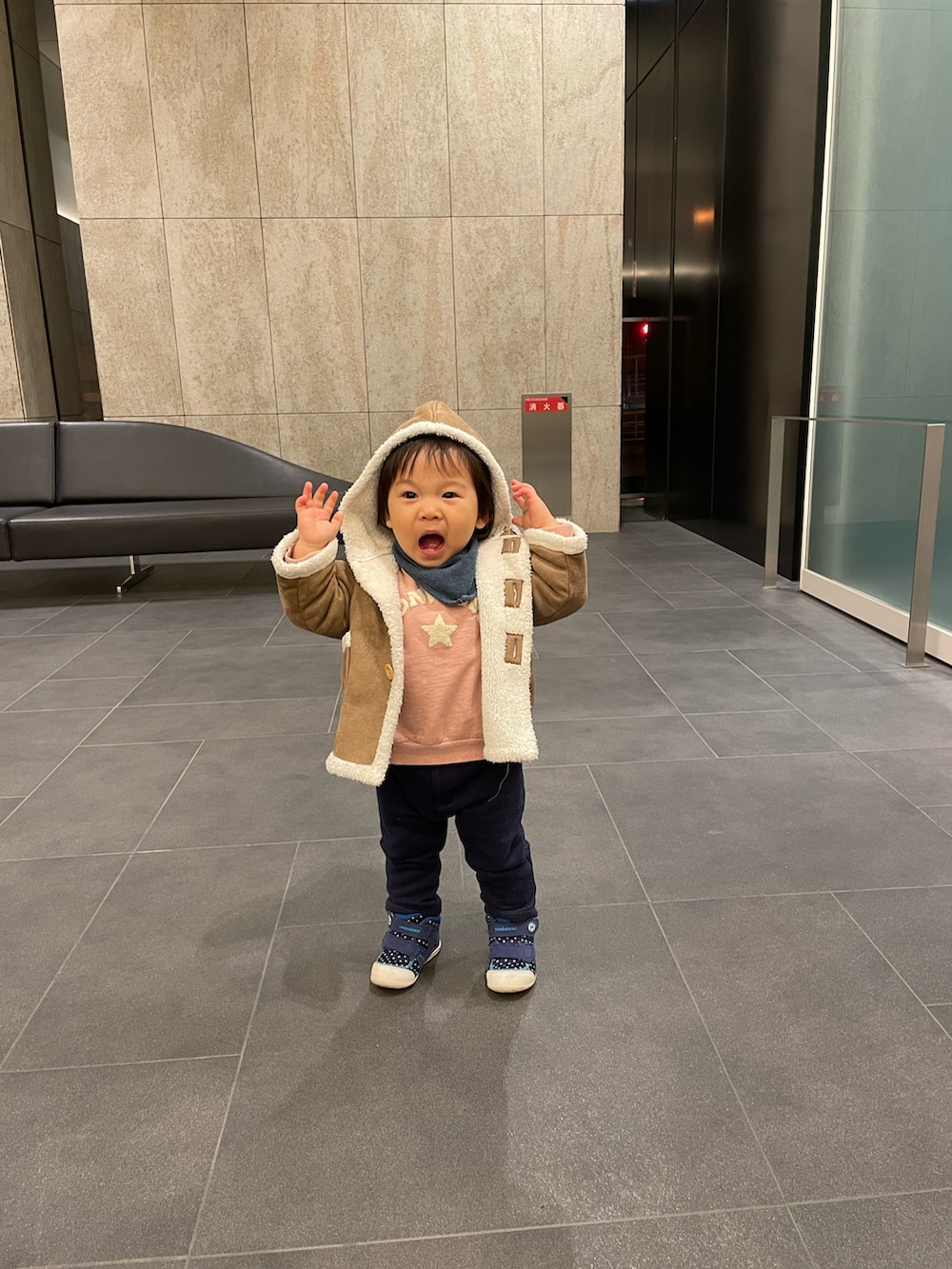 ブルー系のスニーカー、ブラック系のスウェットパンツ、ブラウン系のムートンコートを着用したキッズの冬コーディネートの2枚目の写真