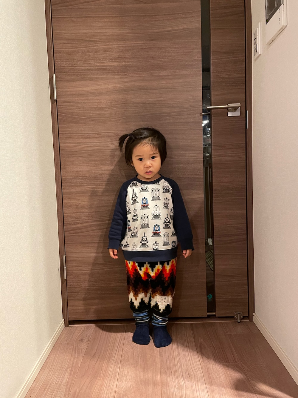 ホワイト系のスウェット、ブラック系のパンツ、ブルー系のレッグウォーマーを着用したキッズの冬コーディネートの4枚目の写真