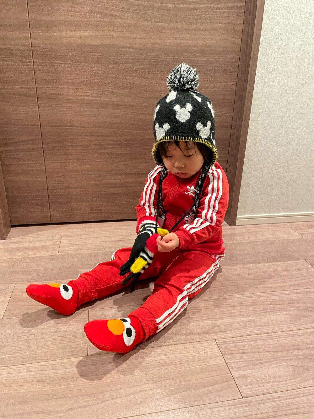 レッド系のその他アウター、ブラック系のニットキャップ/ビーニー、ブラック系の手袋を着用したキッズの冬コーディネートの4枚目の写真