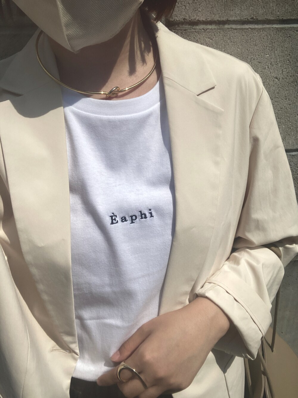 ホワイト系のTシャツ/カットソー、ホワイト系のその他アウター、ベージュ系のハンドバッグを着用したレディースの夏コーディネートの2枚目の写真