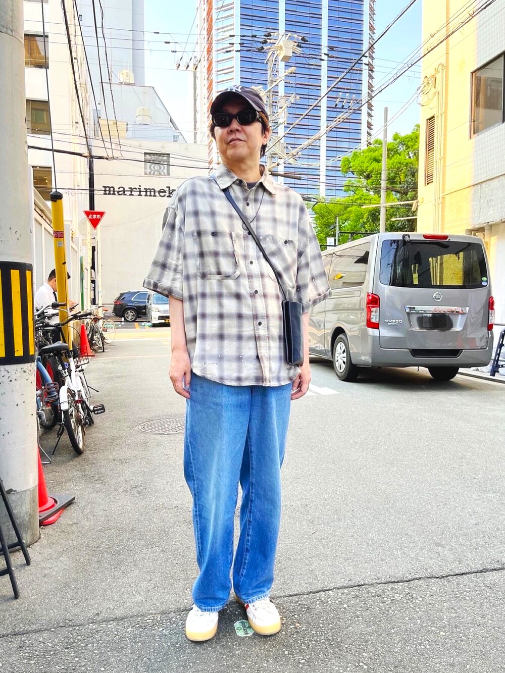 ホワイト系のスニーカー、ブルー系のデニムパンツ、ベージュ系のシャツ/ブラウスを着用したメンズの夏コーディネートの2枚目の写真