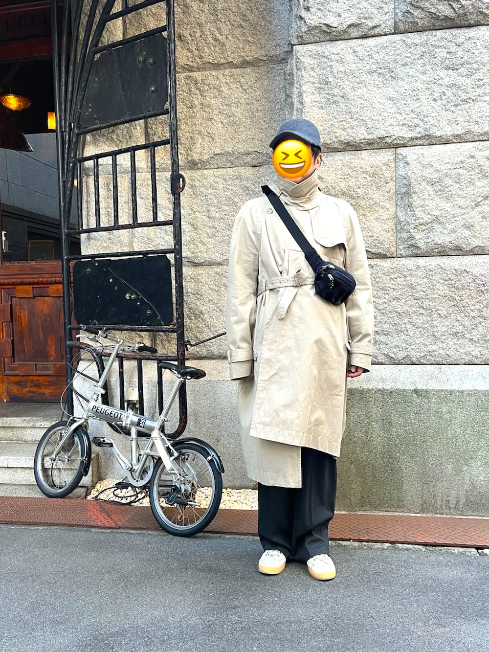 ホワイト系のスニーカー、グレー系のスラックス、ベージュ系のトレンチコートを着用したメンズの冬コーディネートの3枚目の写真