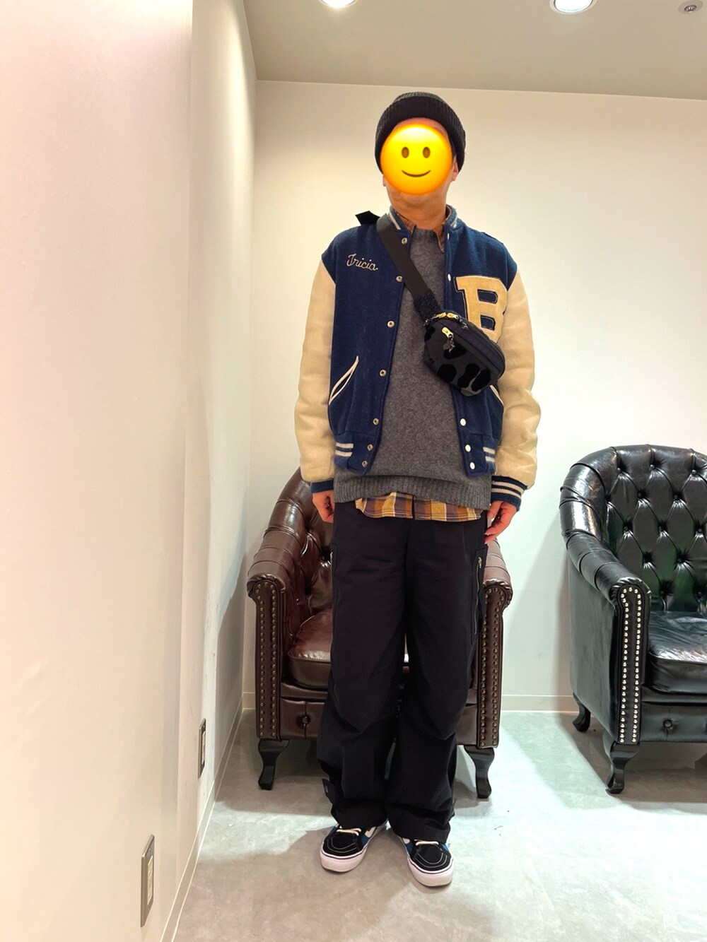 ブルー系のスニーカー、ブラック系のカーゴパンツ、ブルー系のスタジャンを着用したメンズの春コーディネートの2枚目の写真