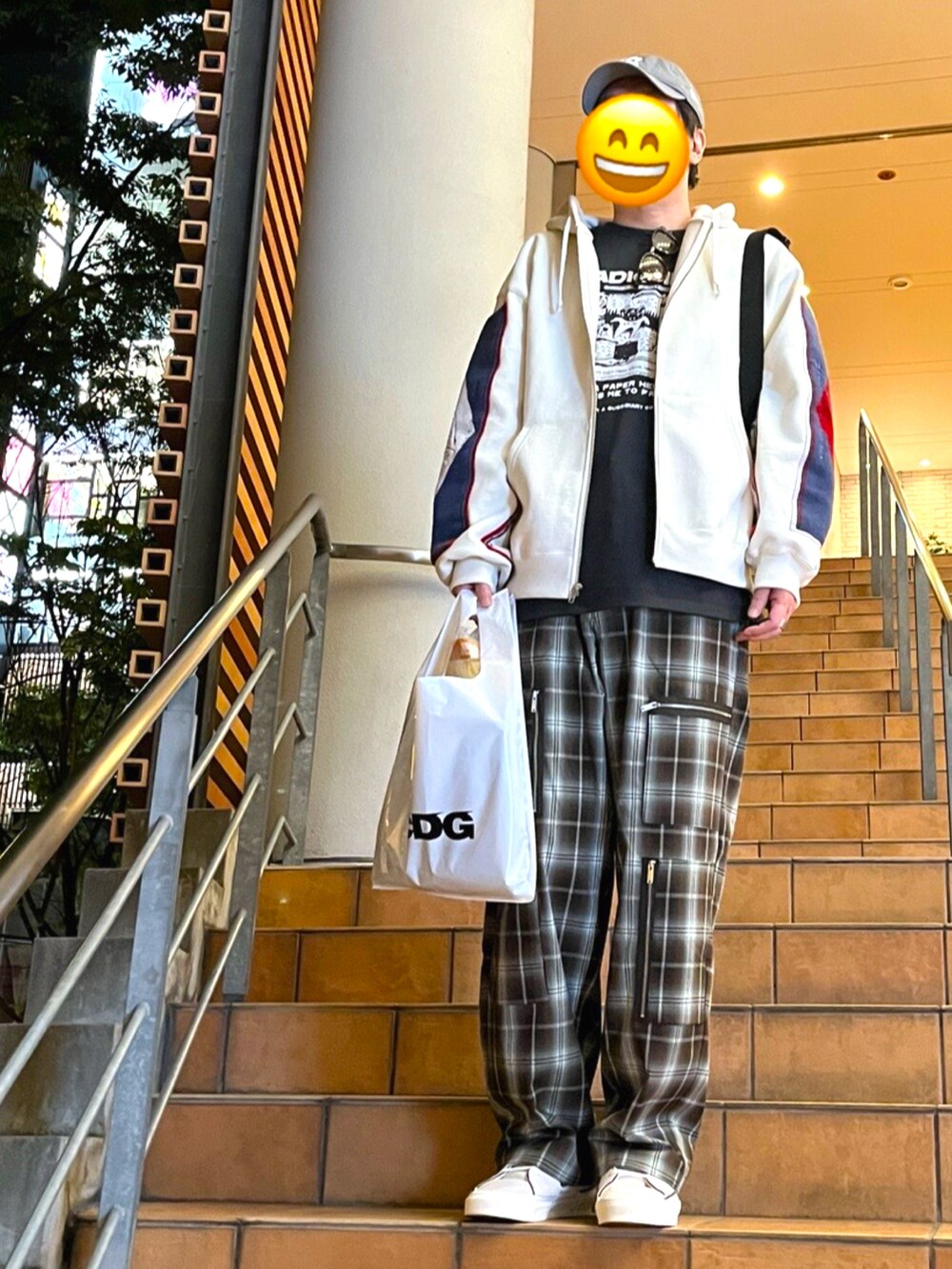 ホワイト系のスニーカー、グリーン系のカーゴパンツ、ブラック系のTシャツ/カットソーを着用したメンズの春コーディネートの2枚目の写真
