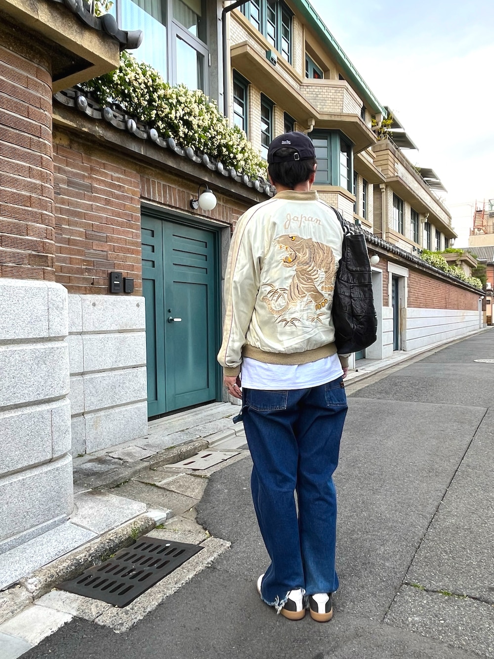 ホワイト系のスニーカー、ブルー系のデニムパンツ、ホワイト系のTシャツ/カットソーを着用したメンズの春コーディネートの2枚目の写真