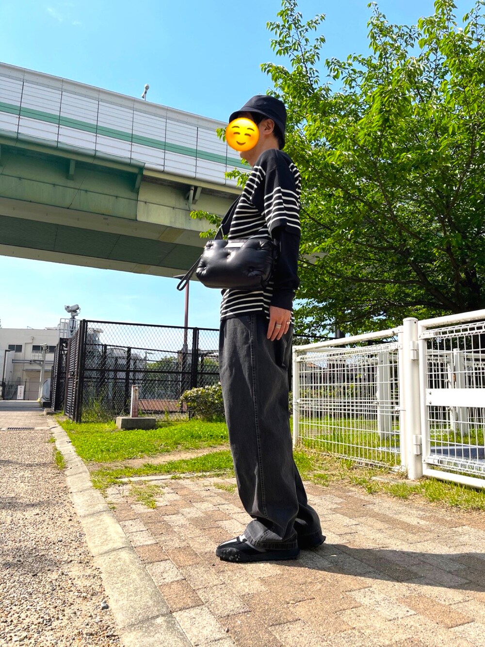 ブラック系のスニーカー、グレー系のデニムパンツ、ブラック系のショルダーバッグを着用したメンズの春コーディネートの3枚目の写真