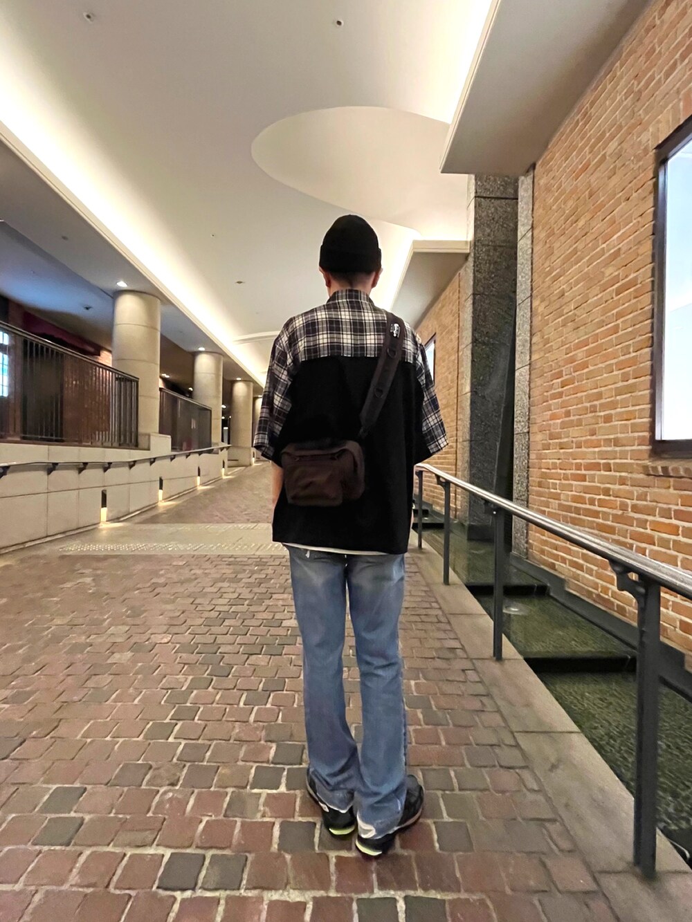 ブラック系のスニーカー、ブルー系のデニムパンツ、ブラック系のシャツ/ブラウスを着用したメンズの秋コーディネートの2枚目の写真