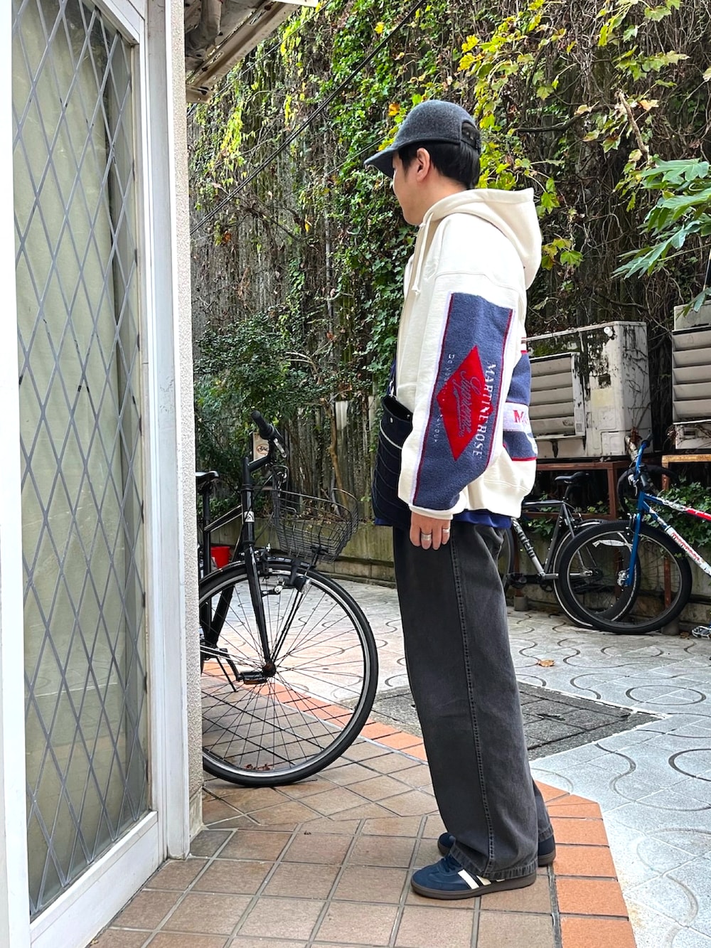 ブルー系のスニーカー、グレー系のデニムパンツ、ホワイト系のパーカーを着用したメンズの秋コーディネートの3枚目の写真