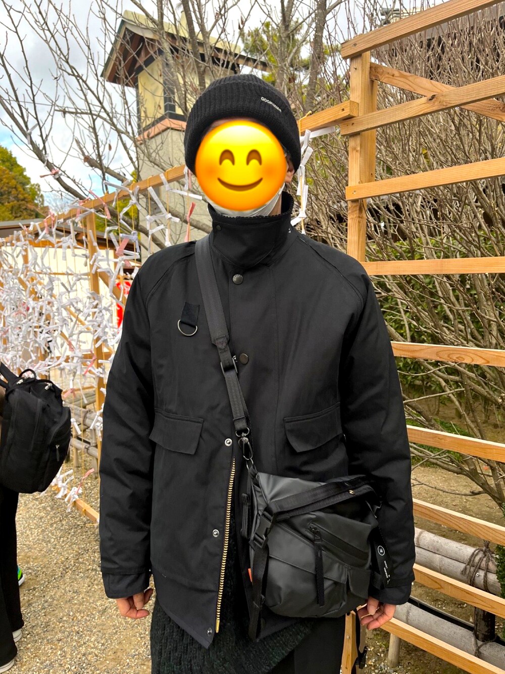ブラック系のスニーカー、ブラック系のスラックス、グリーン系のニット/セーターを着用したメンズの冬コーディネートの3枚目の写真