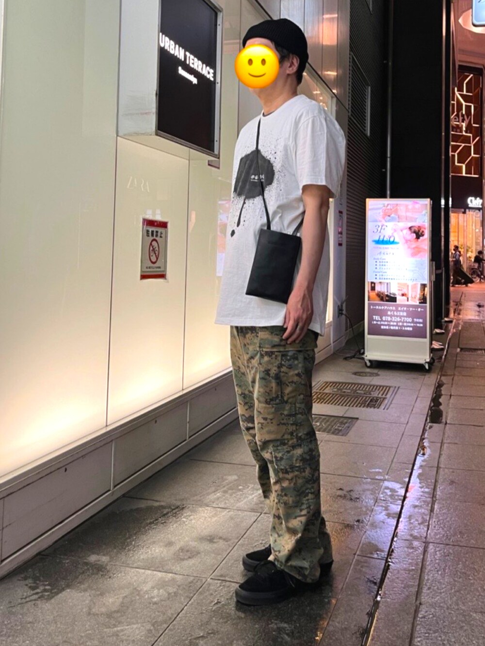 ブラック系のスニーカー、グリーン系のカーゴパンツ、ホワイト系のTシャツ/カットソーを着用したメンズの夏コーディネートの2枚目の写真