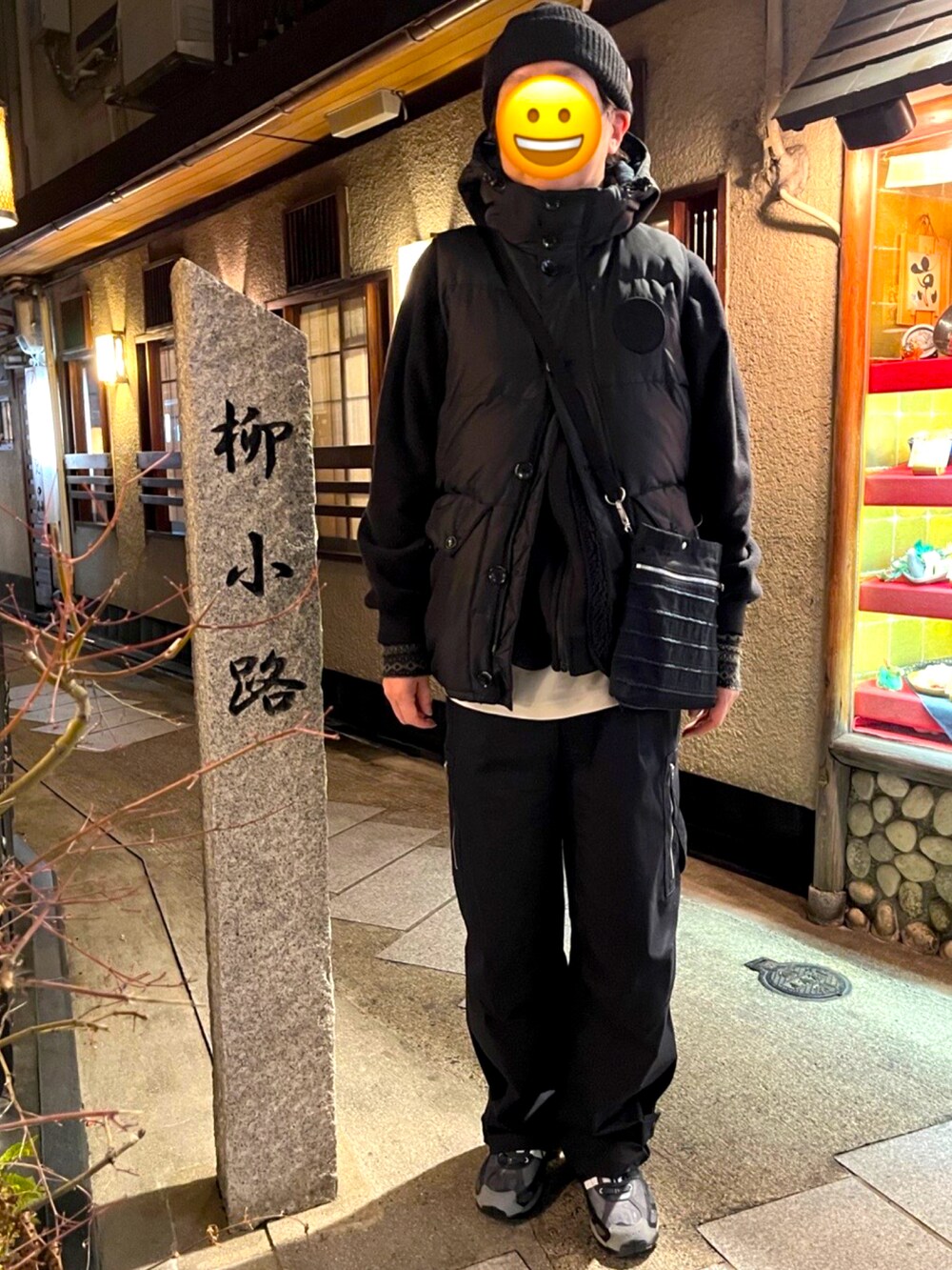 ブラック系のスニーカー、ブラック系のカーゴパンツ、ブラック系のショルダーバッグを着用したメンズの冬コーディネートの2枚目の写真